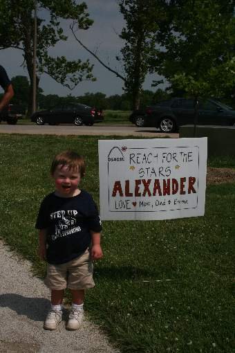 Alexander (AJ) Brewster, age 2, in front of his AJ's Angels sign